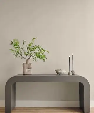 Et lysegråt værelse med et konsolbord