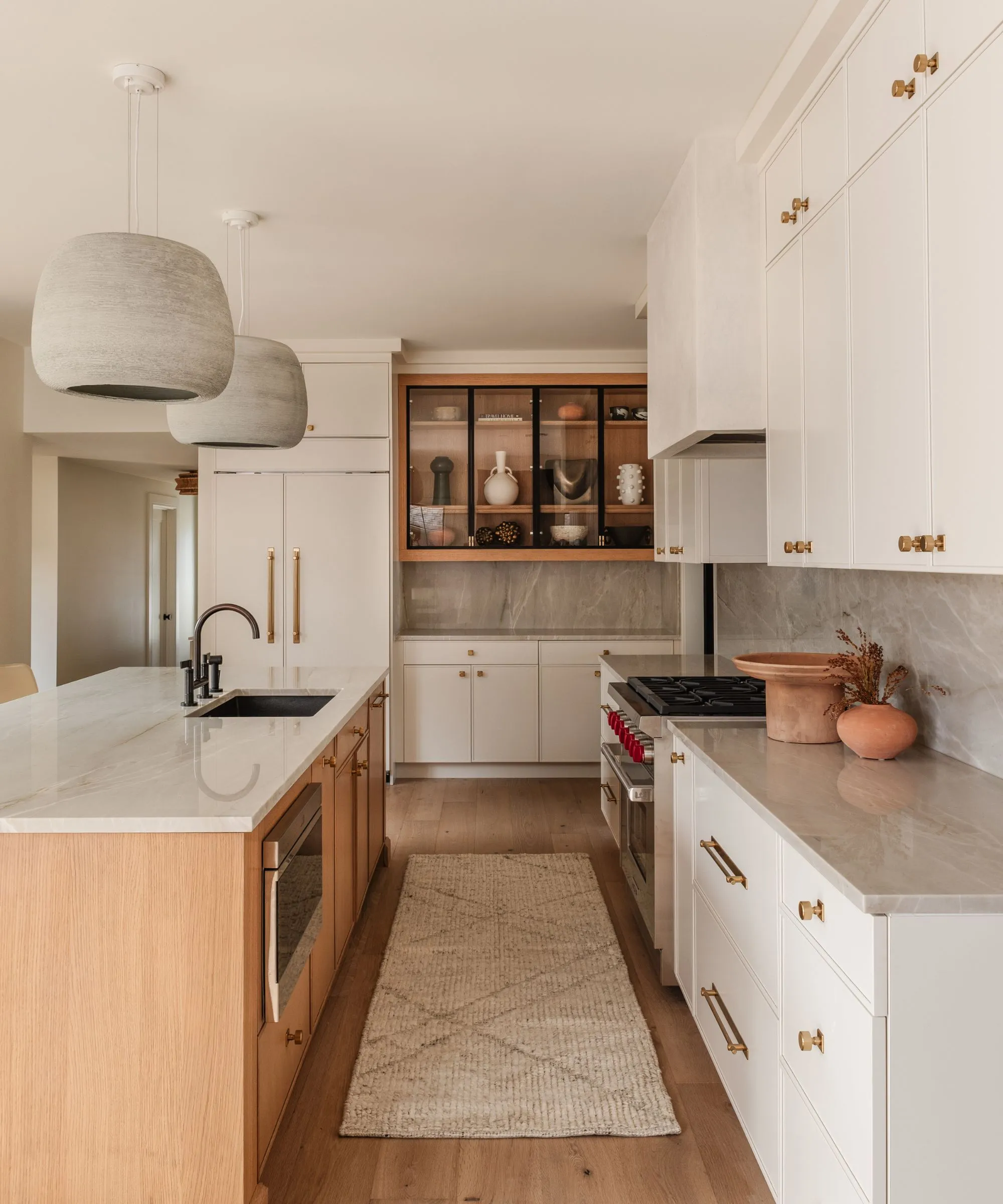 柔らかいグレーの大理石のトップと木製のアイランドを備えた白いキッチン' loading='lazy' title=