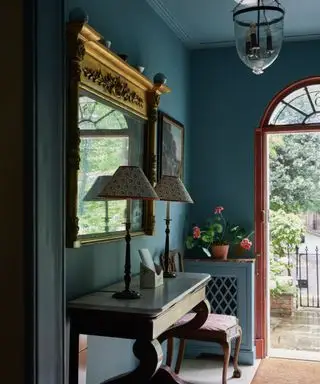 blå entryway i et tradisjonelt london hjem med en uventet rød dør