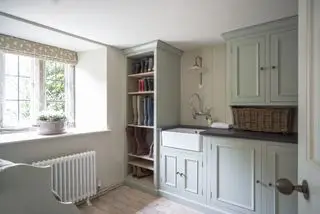 Un grand mudroom avec un radiateur blanc, des rangements muraux et un évier