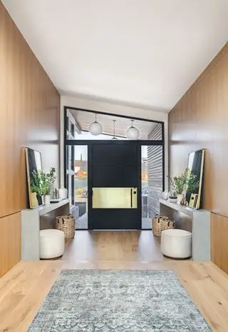 entrée avec murs et sol lambrissés, tapis, consoles, plafond incliné