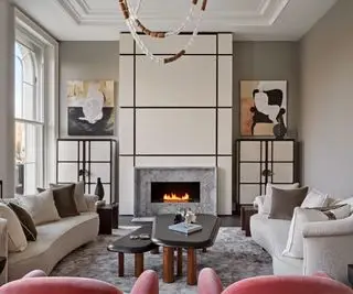 クリーム色の壁とソファ、暖炉とクリーム色のスクリーンキャビネットのあるリビングルーム