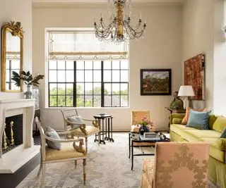 漆喰壁仕上げのリビングルームとシャンデリア付きのゴールドソファ