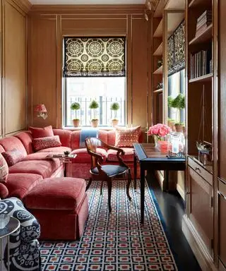 Gemütliche Raumideen mit L-förmigem rosa Sofa und Kissen an der Wand aus Holzpaneelen