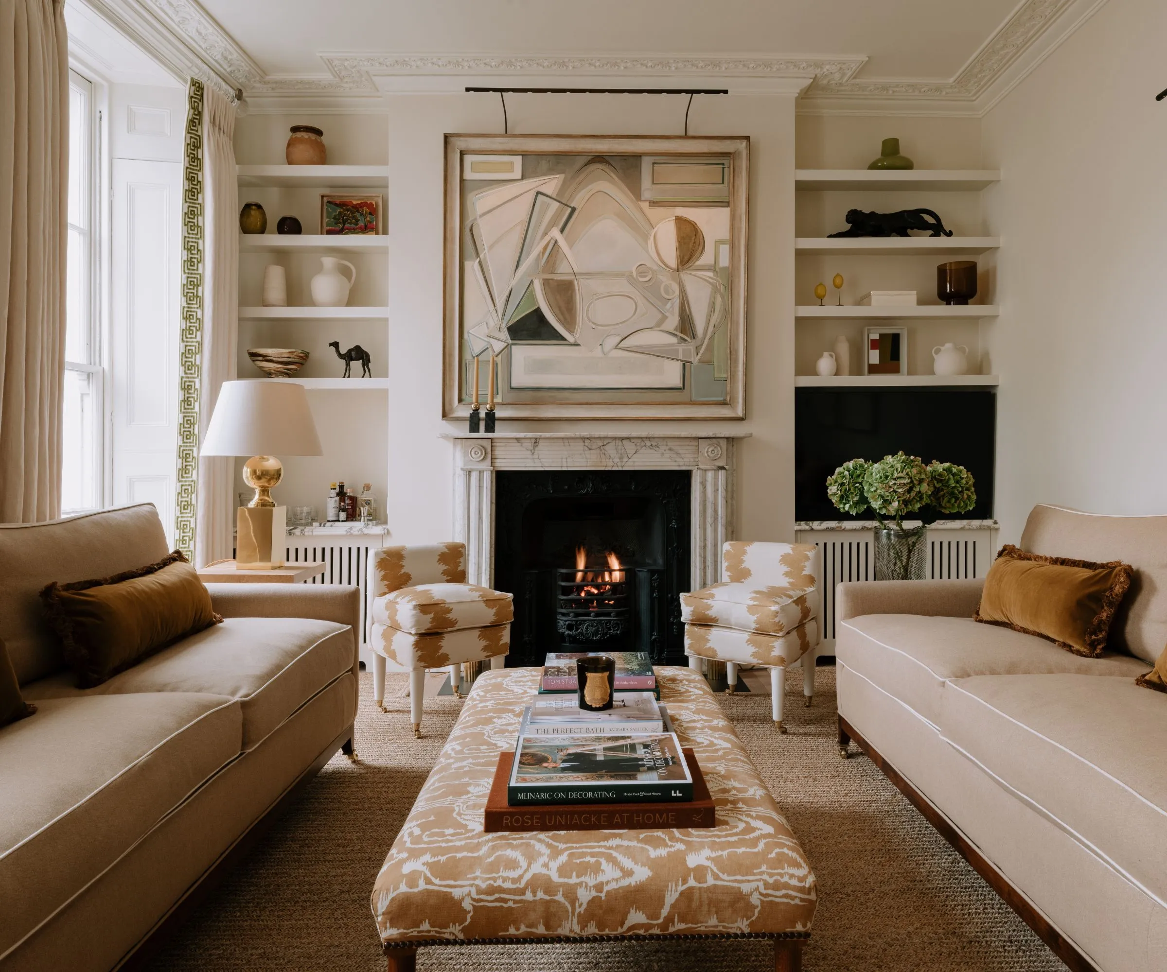 Cozy Modern은 벽난로와 함께 전통적인 거실을 만나서 대리석 벽난로가있는 대리석 벽난로 서라운드 베이지 색 소파와 베이지 색 패턴 오토만' loading='lazy' title=