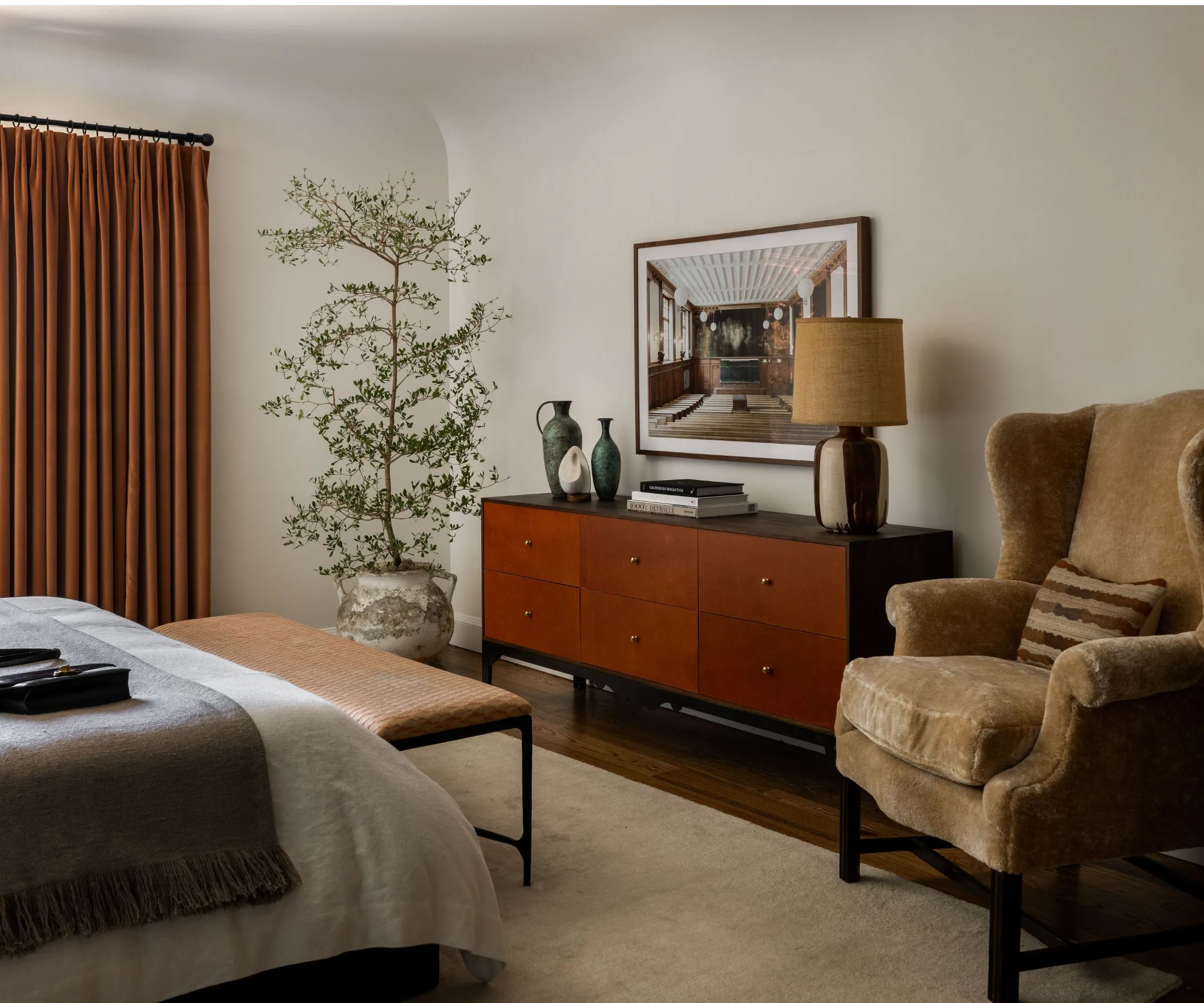 나무 바닥이있는 중성 아늑한 현대 침실 큰 깊은 파일 깔개 화상 오렌지 커튼 검은 색과 티크 우드 보드 보드 식물과 양가죽 의자가있는 중성 스타일의 침대' loading='lazy' title=