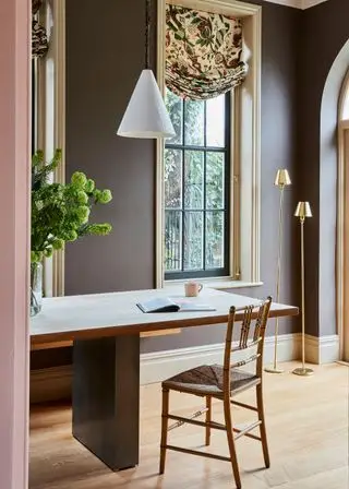 大きな窓と机と椅子のある茶色のホーム オフィス