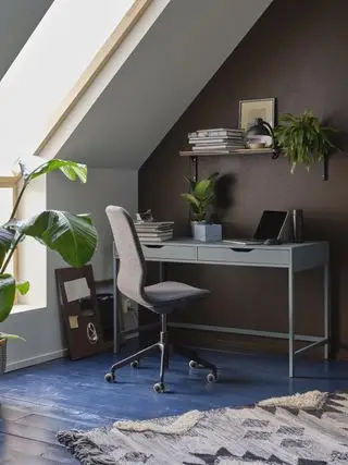 bureau à domicile dans le loft, plancher peint en bleu, bureau sous les avant-toits, chaise, étagère, tapis, plantes