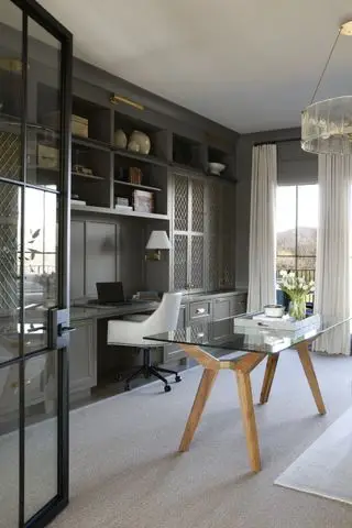 bureau à domicile pour lui avec mur de rangement et bureau sur mesure, table en verre et bois, grand tapis, rideaux crème, suspension en verre, appliques murales, porte noire