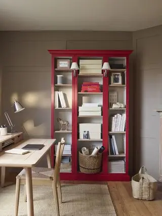 Bureau à domicile en pierre avec armoire peinte en rouge, bureau et chaise en bois blond, tapis en coco, parquet, panier, lampe de bureau chromée