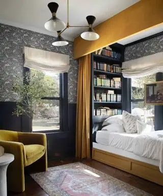 도서관 책장과 커튼 침대가 있는 회색 및 겨자색 침실
