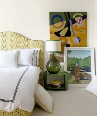 대형 미술품이 있는 흰색 침실과 흰색 시트가 있는 노란색 침대