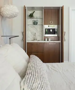 커피 머신과 수도꼭지를 갖춘 목재 음료 공간이 있는 침실