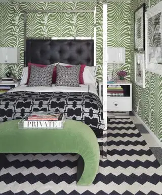 흑백 지그재그 러그와 야자잎 벽지를 갖춘 녹색 침실