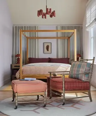 포스터 4개, 나무 의자, 발판, 러그가 있는 침실