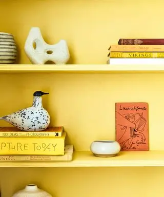 Wände und Regale sind in leuchtendem Gelb gestrichen