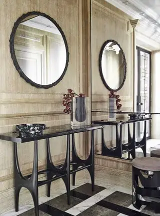 entrée avec panneaux en bois, console noire, miroir noir, mur miroir, sol en marbre