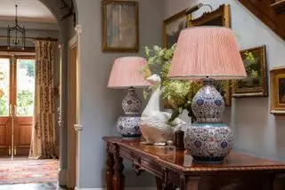 couloir montrant une table console avec des lampes assorties et une porte d'entrée avec un rideau