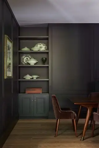 Salle à manger noire avec étagères en alcôve par Cave Interiors