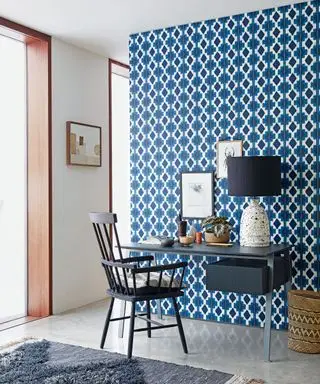 bureau à domicile avec papier peint à motifs géométriques sur mur de séparation
