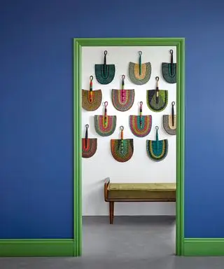 Couloir bleu avec cadre de porte peint en vert et mur de galerie de fans
