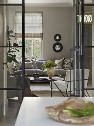 salon neutre avec canapé gris murs taupe stores en lin à rayures portes crittel