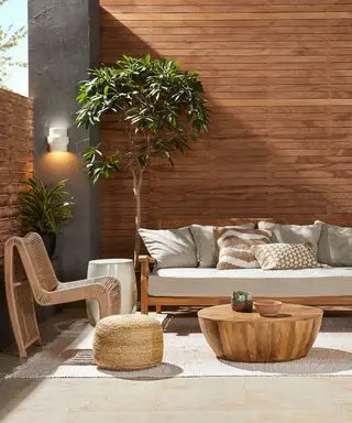 パネル張りの木製の壁の前に設置された屋外用家具