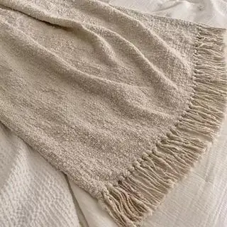 ベッドに掛けられたブークレのスローブランケット