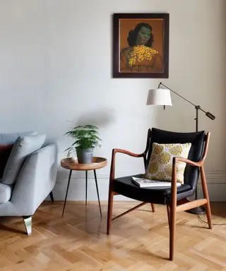 Un salon moderne du milieu du siècle avec un sol à chevrons, une chaise en bois et une influence scandinave.
