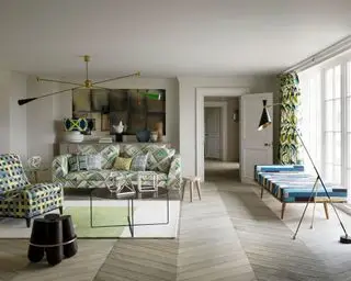 Un salon moderne de style scandinave du milieu du siècle avec des tissus d'ameublement verts et un éclairage tendance.