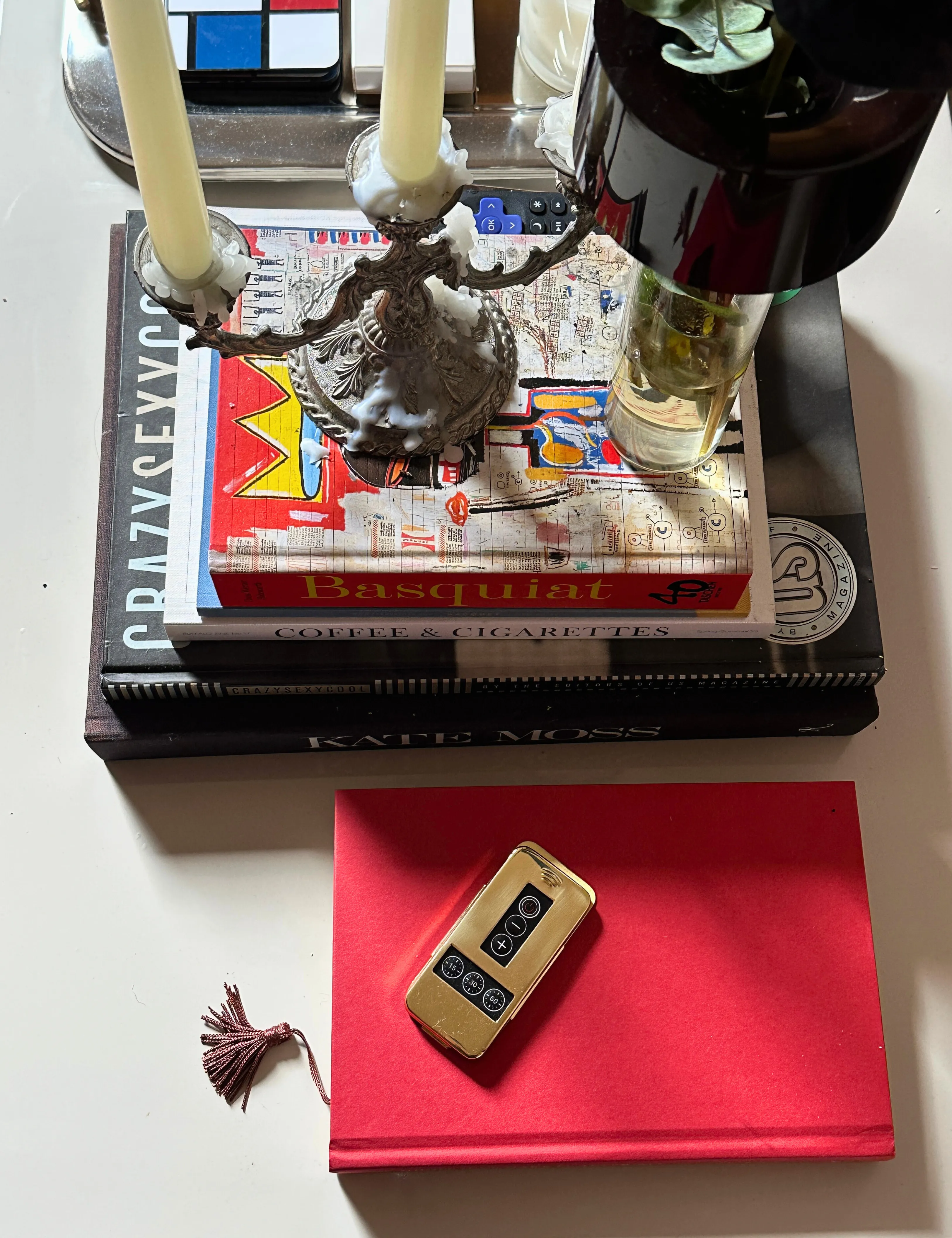 Gold Pooky Lighting Remote Control sidder øverst på et sofabord sammen med indsamlede genstande' loading='lazy' title=