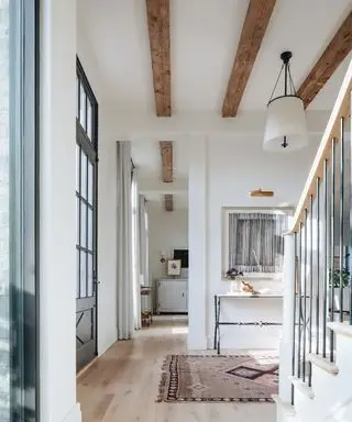 entrée de style ferme avec poutres en bois et escalier