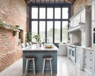 Cuisine de ferme avec murs en briques et éléments de cuisine de style shaker