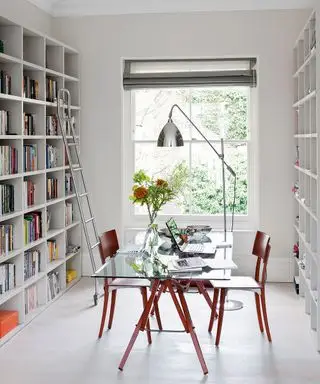 Bureau et bibliothèque entièrement lumineux et aérés à lumière blanche, fenêtre à guillotine, table/bureau en verre, lampe de travail design chromée