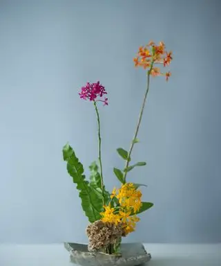 Et Ikeaba blomsterarrangement med lyse lilla og orange blomster