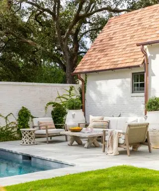 Patio con pareti bianche e divano da esterno