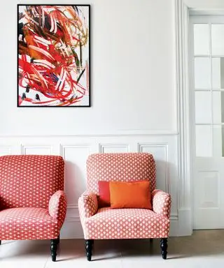 Salle blanche avec art moderne et chaises à motifs roses