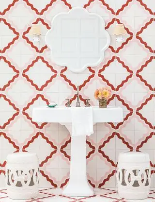 Salle de bains rose avec mur carrelé et accessoires blancs