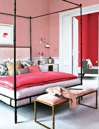 Chambre rose avec papier peint à motifs et lit à baldaquin noir
