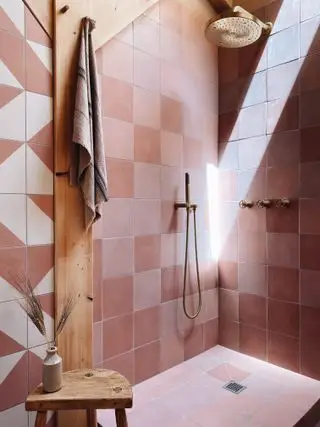 Conception de salle de bain avec un mélange de carreaux roses par The Landscape Lodge