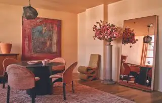 Espace de vie contemporain avec murs en plâtre rose et chaises en velours