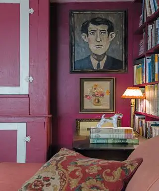 salon rose avec murs et coussins peints en rose, livres et peintures sur les murs