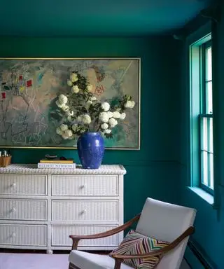 Chambre avec mur et plafond peints en vert avec fauteuil