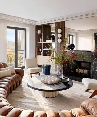 Sofá curvo moderno y exclusivo en un apartamento ecléctico con chimenea de mármol