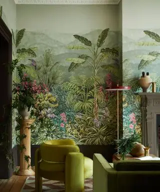sala de estar con un gran mural tropical y muebles de terciopelo verde