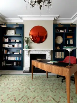 Bureau à domicile bleu avec des touches de couleur et une cheminée rustique