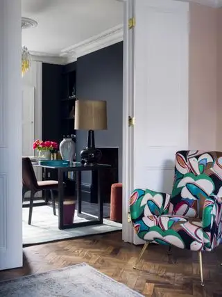 Bureau à domicile avec murs noirs à côté d'un salon