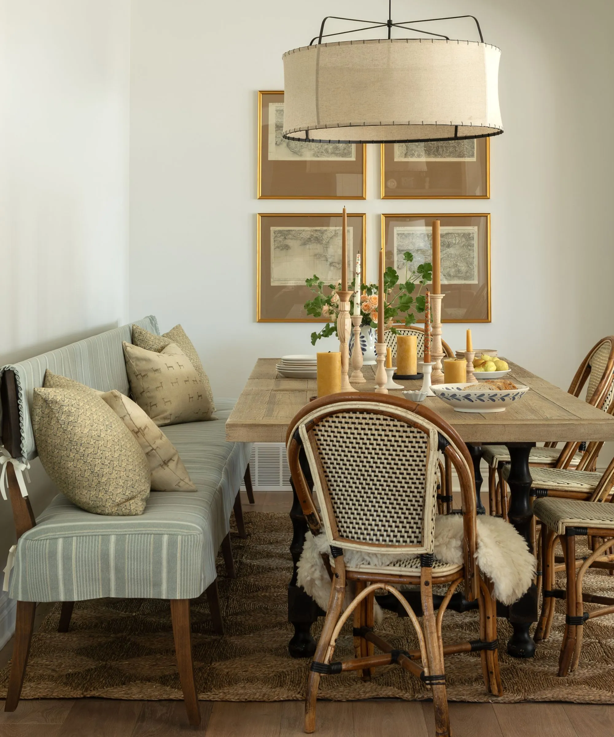 neutrálna jedáleň s dubovým stolom francúzske bistro stoličky 4 vintage potlače na stene jedálenská lavica s modro-bielym pruhovaným čalúnením' loading='lazy' title=