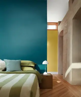 couleurs qui vont avec le bleu sarcelle, chambre bleu sarcelle avec mur jaune derrière, literie verte et blanche, parquet en bois dur de tons moyens