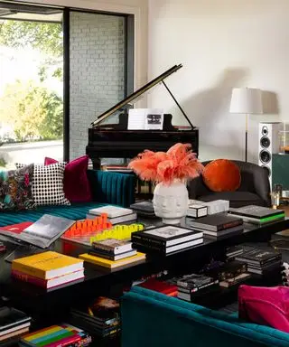 couleurs associées au bleu sarcelle, salon avec piano, canapés bleu sarcelle, grande table basse noire, fauteuil noir, livres de table basse